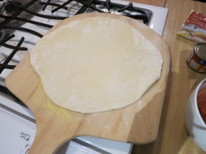 Dough rolled out and placed on pizza paddle.